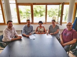 Julien Larios (MyConnectivity), Joe Nilles (Bourgmestre de la Commune de Berdorf), Susy Seyler-Grommes (Administration Communale de Berdorf), Geraldine Knudson (MyConnectivity), and Daniel Scharff (Administration Communale de Berdorf) signing the Letter of Intent.